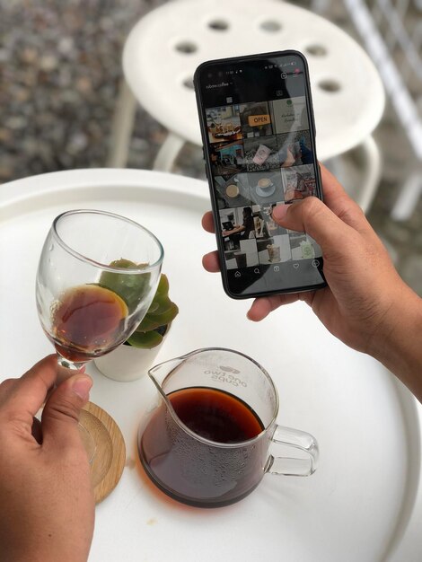 Mano cortada de una mujer sosteniendo café en la mesa