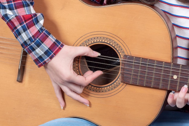 Foto mano cortada de una mujer tocando la guitarra