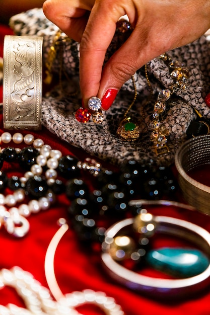 Foto mano cortada de una mujer tocando joyas