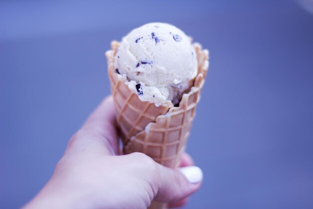 Foto mano cortada de una mujer tomando un cono de helado