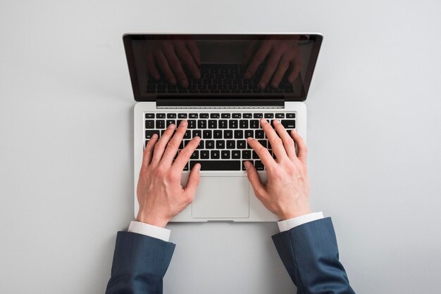 Mano cortada de una mujer usando una computadora portátil