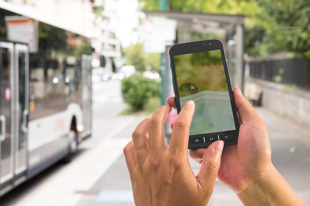 Foto mano cortada de una mujer usando un teléfono móvil al aire libre