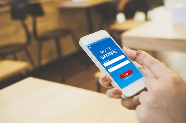 Mano cortada de una mujer usando un teléfono móvil en un café