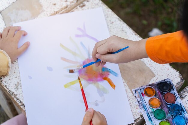 Foto la mano cortada de los niños pintando