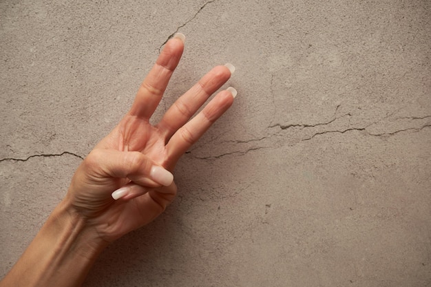 Foto mano cortada de una persona contra la pared