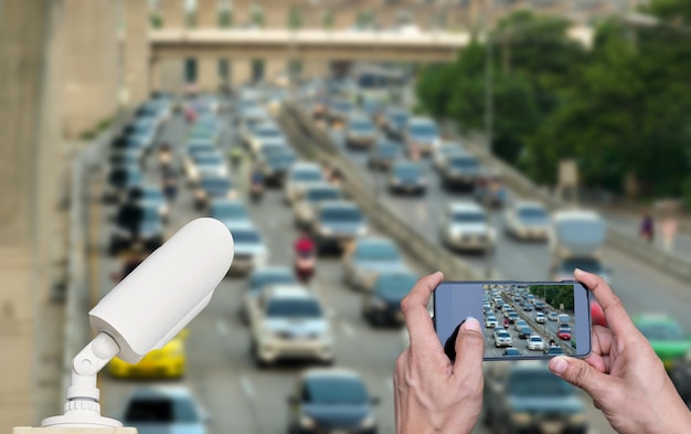 Foto mano cortada de una persona fotografiando coches en la calle