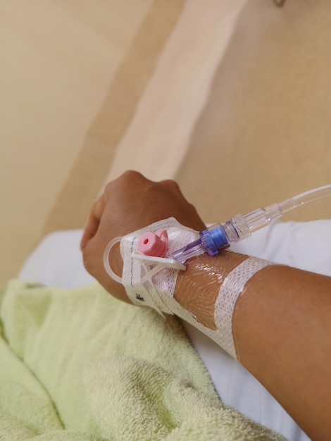 Foto la mano cortada de una persona con un goteo en el hospital.