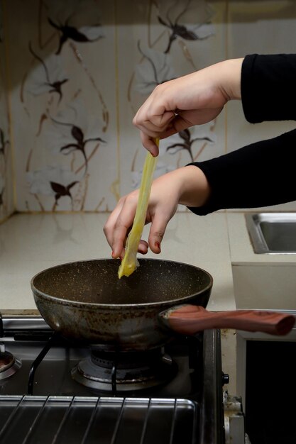 Mano cortada de una persona preparando comida en la cocina