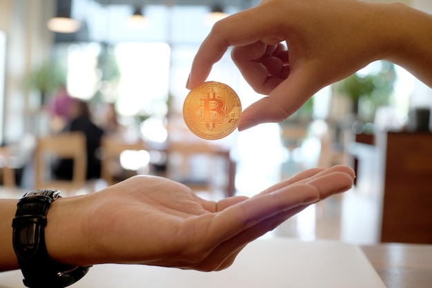 Foto mano cortada de la persona que da el bitcoin