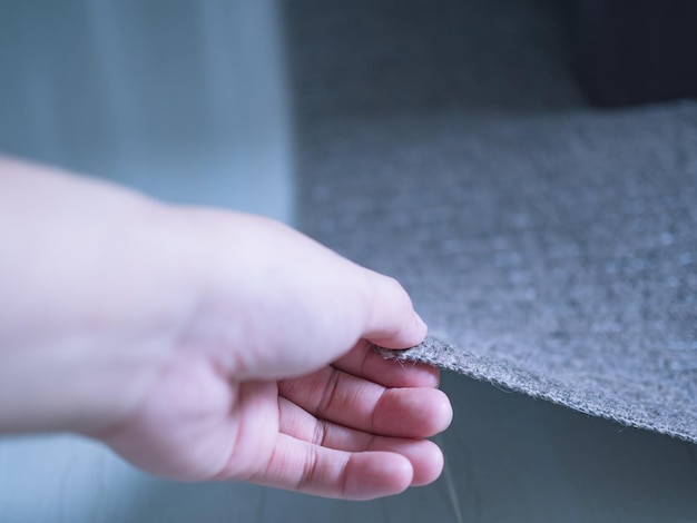 Foto mano cortada de una persona que sostiene una alfombra en casa