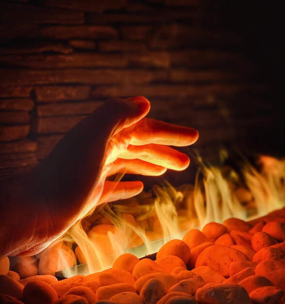 Foto mano cortada de una persona sobre el fuego