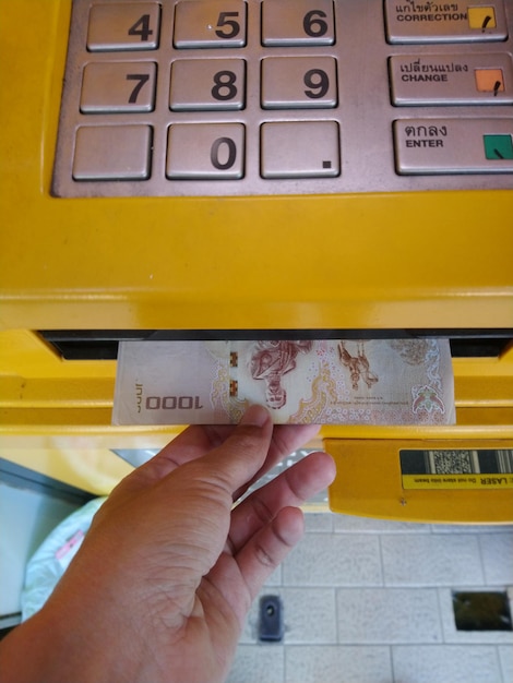 Foto mano cortada sacando dinero de un cajero automático