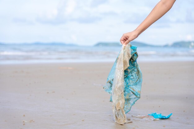 Foto mano cortada sosteniendo la basura en la playa