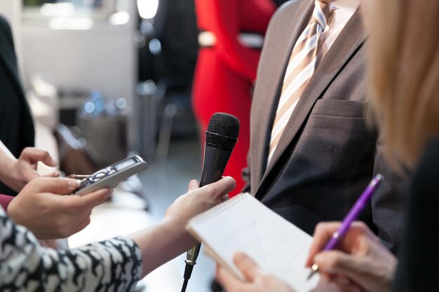 Foto mano cortada sosteniendo el micrófono mientras entrevista a un hombre de negocios