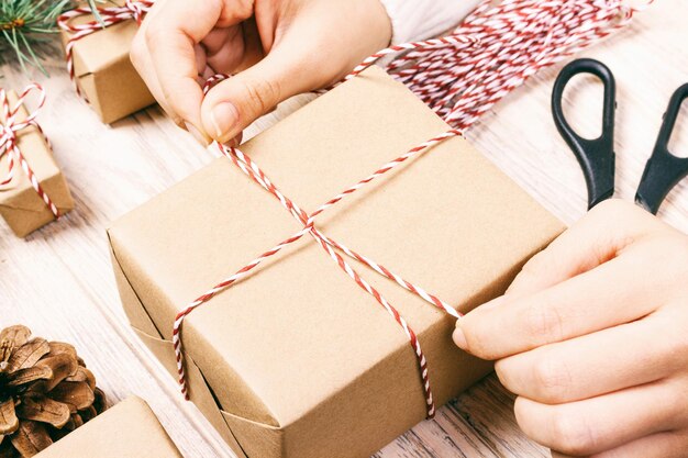 Foto mano cortada sosteniendo un regalo de navidad en la mesa