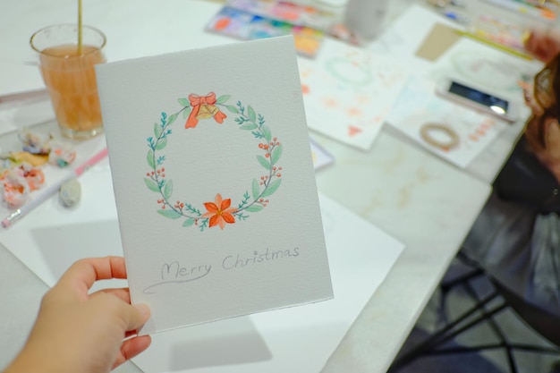 Foto mano cortada sosteniendo una tarjeta de navidad