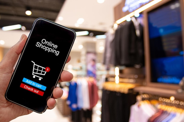 Mano cortada sosteniendo un teléfono inteligente en la tienda