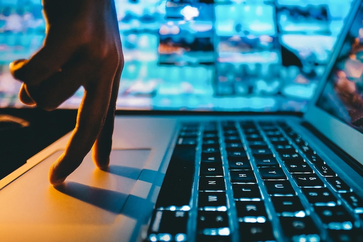 Foto mano cortada usando una computadora portátil en la mesa