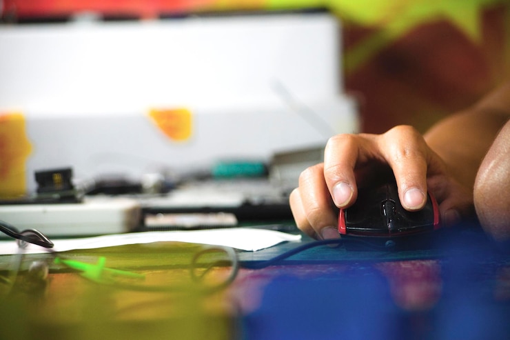 Foto mano cortada usando el ratón de la computadora en el escritorio de la oficina