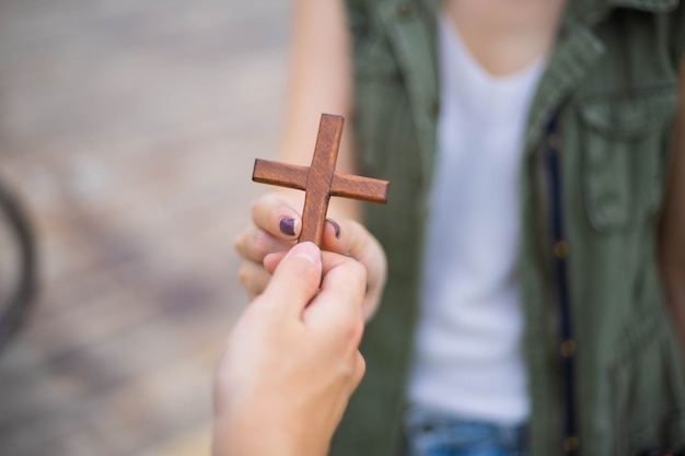 De la mano con la cruz. Concepto de esperanza, fe, cristianismo, religión, iglesia en línea.