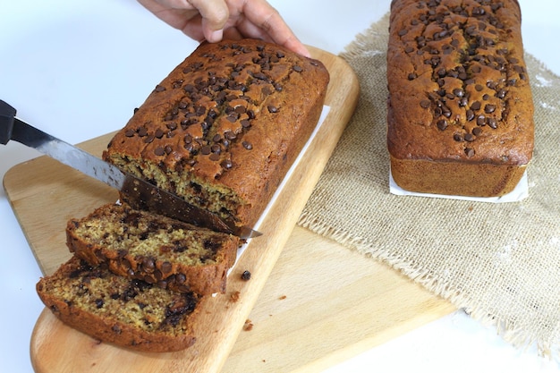 La mano de una dama cortando el Pan de Plátano