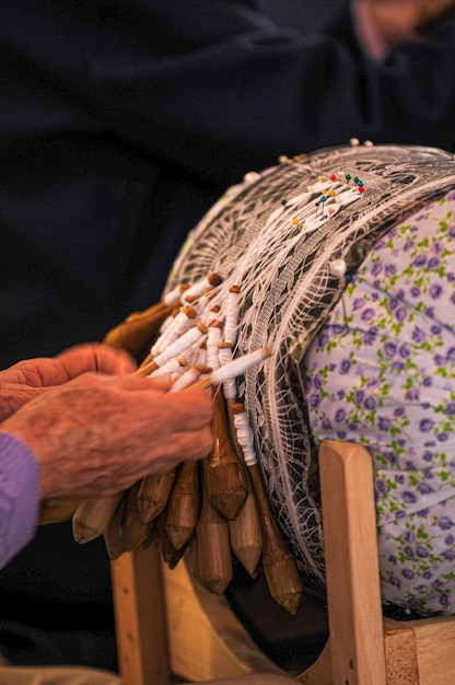 La mano de una dama haciendo encaje con una tradición azoriana de bolillos