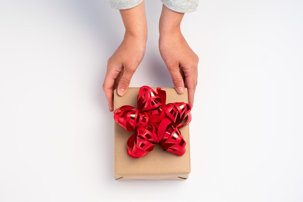 Mano dando una caja de regalo sobre fondo blanco.