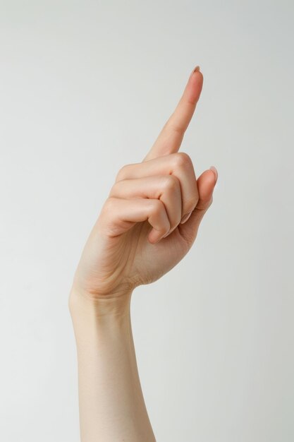 Foto una mano con un dedo apuntando hacia arriba contra un fondo blanco