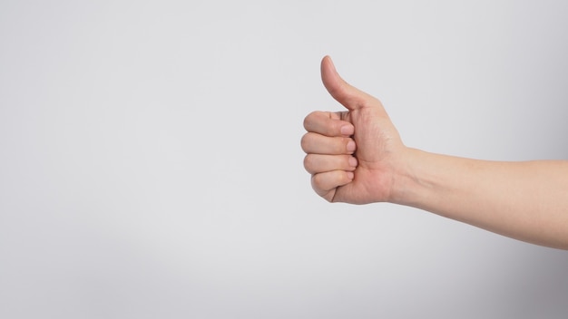 La mano derecha está haciendo como o pulgar hacia arriba signo sobre fondo blanco.