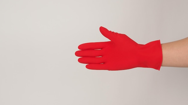 Foto mano derecha con guantes de látex rojos sobre fondo blanco.