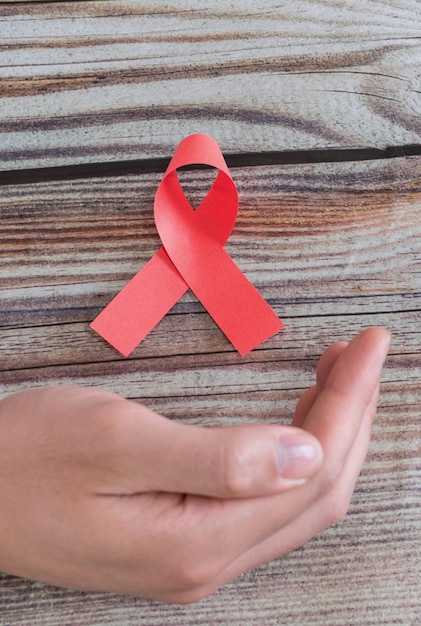 Mano del día mundial del sida con el símbolo de la cinta roja