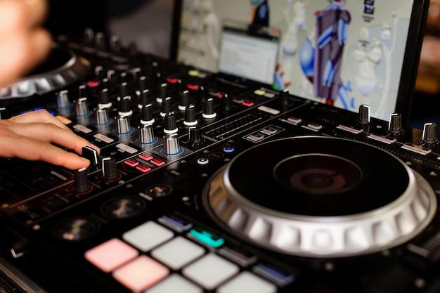 La mano del DJ en la mesa de mezclas Dj en los tocadiscos mano en un primer plano de la mesa de mezclas Chica Hombre DJ en el control remoto de la mesa de mezclas