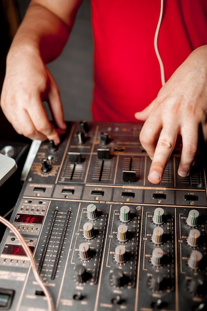 La mano del DJ en el mezclador de DJ Dj en los tocadiscos La mano del DJ en un primer plano del mezclador de DJ