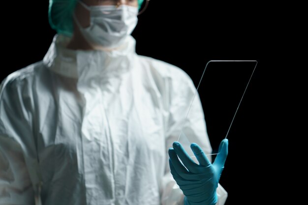 La mano del doctor sostiene la pantalla transparente de la tableta que muestra la pantalla vacía