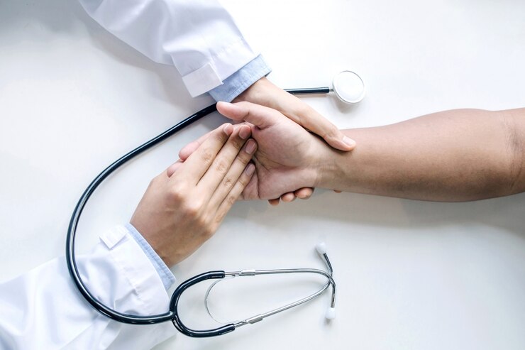 Foto mano del doctor tranquilizador paciente masculino y estetoscopio