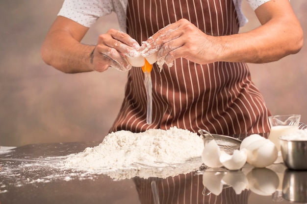 Mano elegante chef inconformista mezcla de yema de huevo en el hermoso fondo