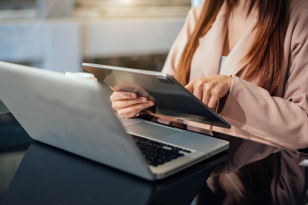 Mano de la empresaria trabajando con una computadora nueva y moderna y escribiendo en el diagrama de estrategia del bloc de notas como concepto de luz de la mañana