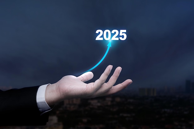 La mano del empresario muestra una flecha aumentada de 2025 Desafío de oportunidad de planificación y estrategia de negocios
