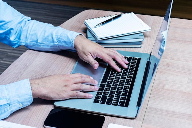 Mano de empresario presionando el teclado portátil