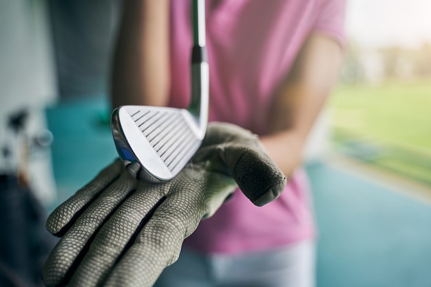 una mano enguantada demostrando un club de golfista profesional frente a la cámara