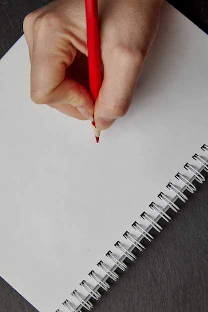 Foto mano escribiendo en un cuaderno con lápiz