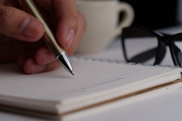 Mano escribiendo en un cuaderno