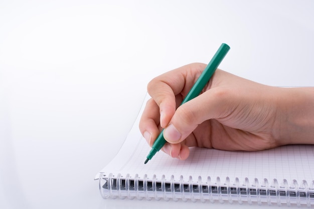 Mano escribiendo en un cuaderno