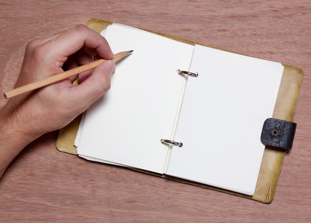 Foto mano escribiendo nota en blanco