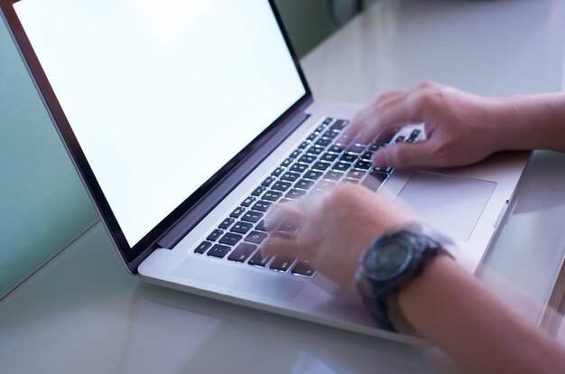 Mano escribiendo en el teclado de la computadora portátil rápidamente la mano es un efecto de desenfoque de movimiento