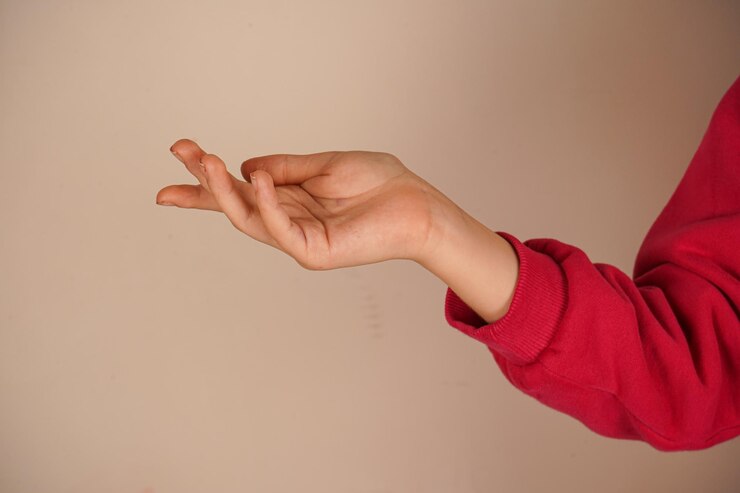 Foto la mano está extendida con la palma hacia arriba en un fondo claro de la pared la mano está hasta el codo la palma con los dedos extendidos