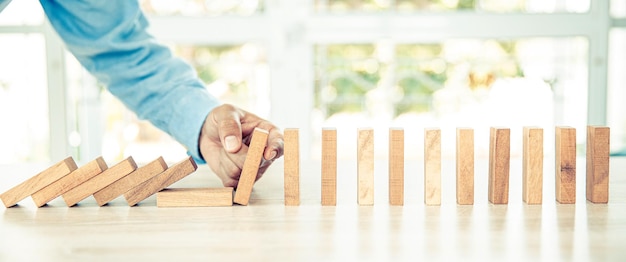 Foto la mano evita que el bloque de madera no caiga dominó