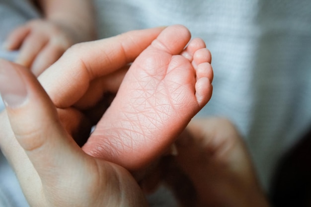 La mano feliz del bebé y el trasfondo de los padres