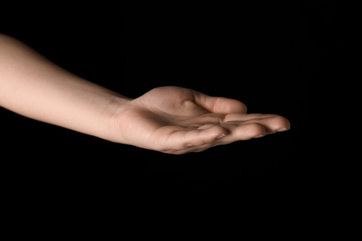 Foto mano femenina aislada en la oscuridad