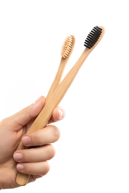 Mano femenina con un cepillo de dientes de bambú ecológico